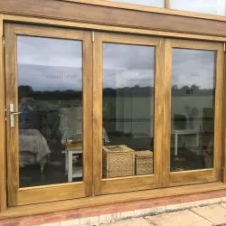 Triple bifolding door with large glass panes to allow maximum light to flood into the interior