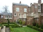 192 - Rear elevation of property showing windows with a cottage bar design and sash window to the upper right of the photo