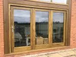 Triple bifolding door with large glass panes to allow maximum light to flood into the interior
