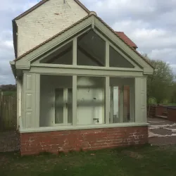 Gable end of orangery featuring panelling and cornice