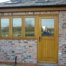 233 - Back door combining boards at base and glazed unit. Manufactured in Idigbo and spray finished in a light oak colour