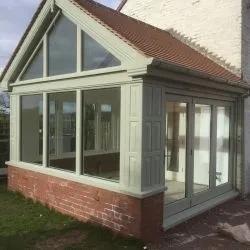 Orangery showing side elevation of bifolding door and gable end with fixed light windows. Complete with tiled roof