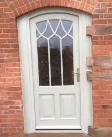 094 - Arched front door with panelled base and curved bars