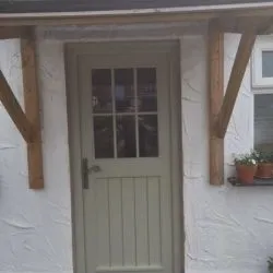 079 - Front door with Georgian style glazed upper section and boarded base section; ironmongery is a monkey tail handle