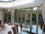 144 - Bifolding doors in a charcoal grey spray finish along with French doors with floating mullion to the left hand side