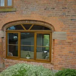 117 - Feature arched window with sunrise bars within the arch and cottage bar design on the triple light window