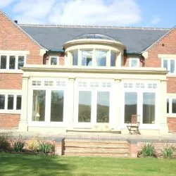260 - Triple set of French doors onto a patio area spray finished in white and feature Georgian style top lights over the doors